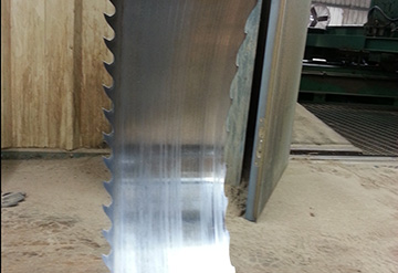 Bandsaw blade shown after running 4 hours cutting walnut at Missouri Pacific Lumber. They use Lubie GP. Justin Wells, head filer, says all his saws come back looking like this. Bandsaw blade shown